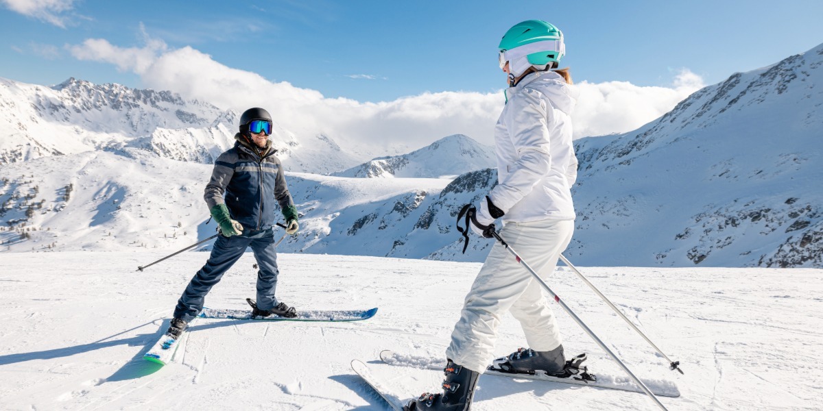 Woman on top of the mountain taking a ski lesson