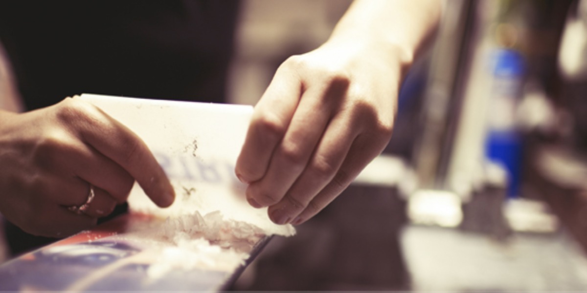 Woman scraping wax off a ski