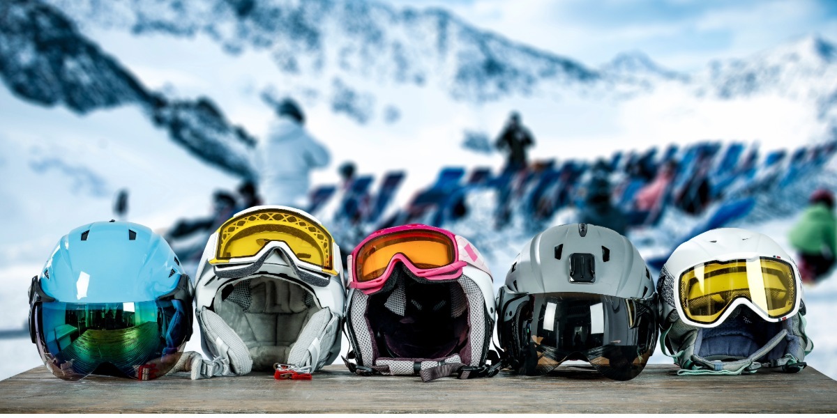 A row of ski helmets on a table.